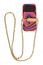 A phone case with a vibrant multicolor swirl pattern in pink, purple, orange, and black, featuring a gold chain strap and a gold clasp with a decorative emblem, shown on a light beige background.