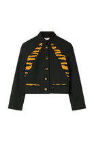 A black cropped jacket with bold orange tiger-stripe patterns on the chest and lower front pockets, featuring gold-tone buttons, shown flat against a light beige background.