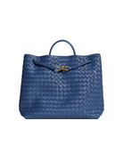 Blue woven handbag with a gold clasp on a light gray background