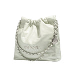 Light green quilted Chanel bag with chain detail on a white background