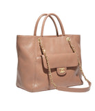 Beige handbag with gold chain and logo on a light gray background