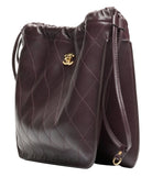 Brown quilted handbag with gold logo on a white background