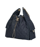 Black quilted handbag with gold chain detail on a white background