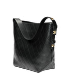 Black quilted handbag with gold hardware on a white background