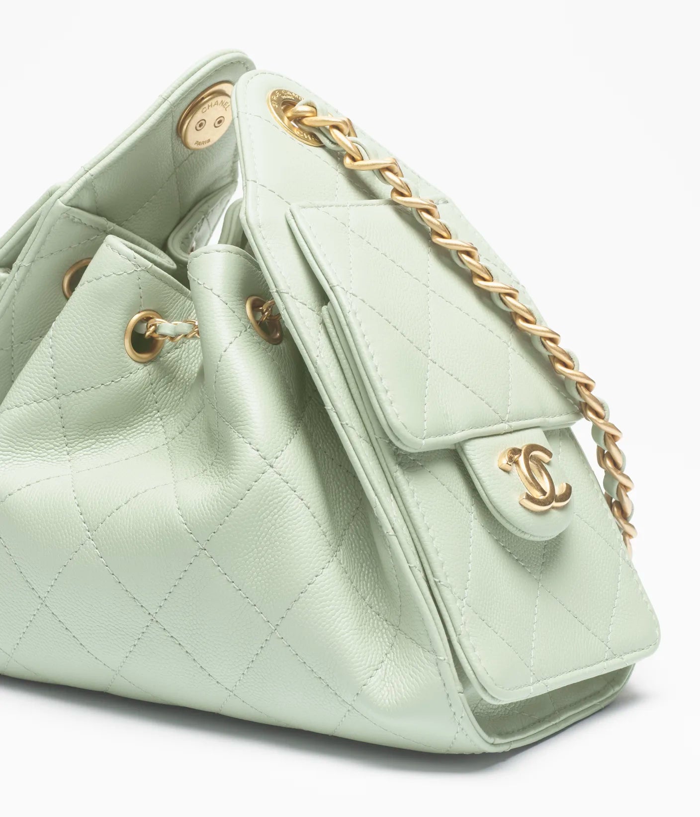 Light green quilted handbag with gold chain and hardware on a white background