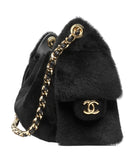 Black fluffy bag with gold chain and Chanel logo on a white background