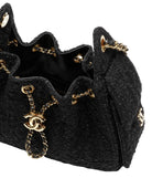 Black textured handbag with gold chain and CC logo on a white background