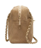 Beige suede handbag with gold chain strap on a white background