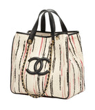 Chanel tote bag featuring a cream-colored woven body with vertical black and red stripes, black leather handles and trim, a black interlocking CC logo, and a gold-tone chain strap.
