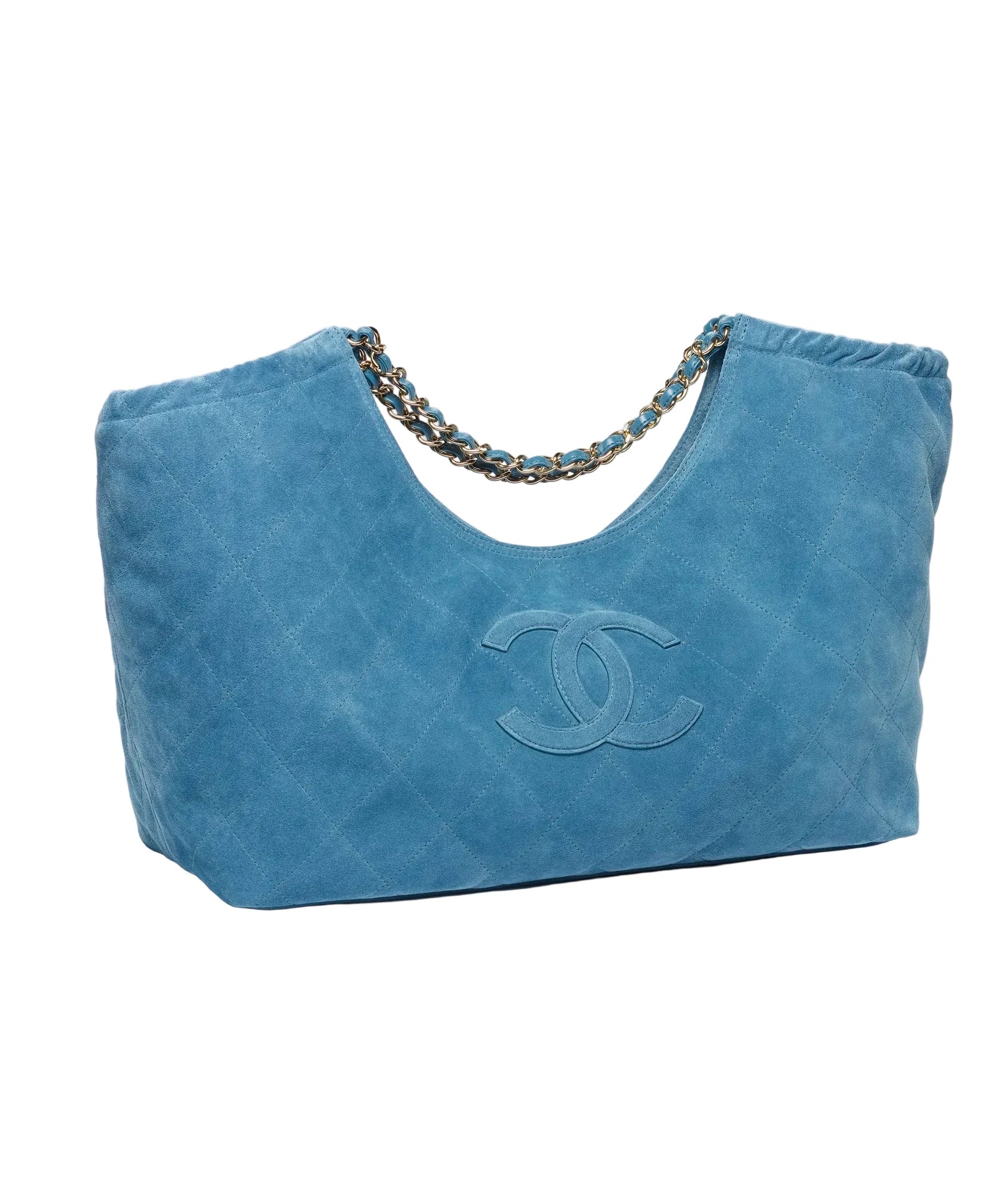 A blue suede Chanel hobo bag with a chain shoulder strap and an embossed CC logo on the front, photographed on a clean white background.