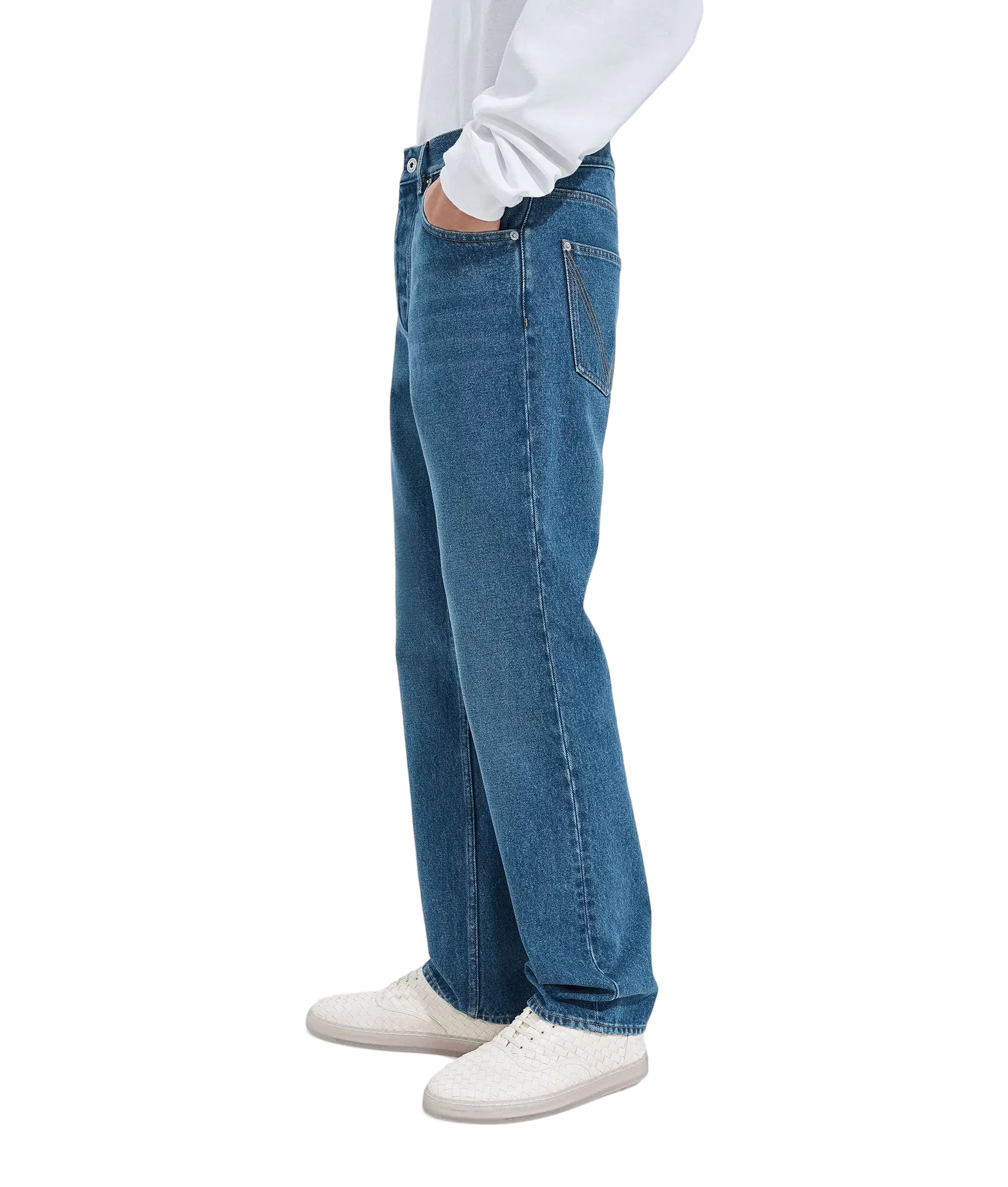 Person wearing blue jeans and white sneakers on a white background