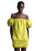 A model wearing a bright yellow-green off-the-shoulder mini dress with a textured jacquard pattern, set against a plain light gray background.
