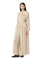Woman wearing a long, patterned dress on a white background