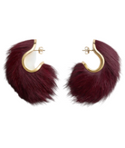 A pair of gold-tone hoop earrings with large, fluffy burgundy faux fur pendants, displayed on a clean white background.