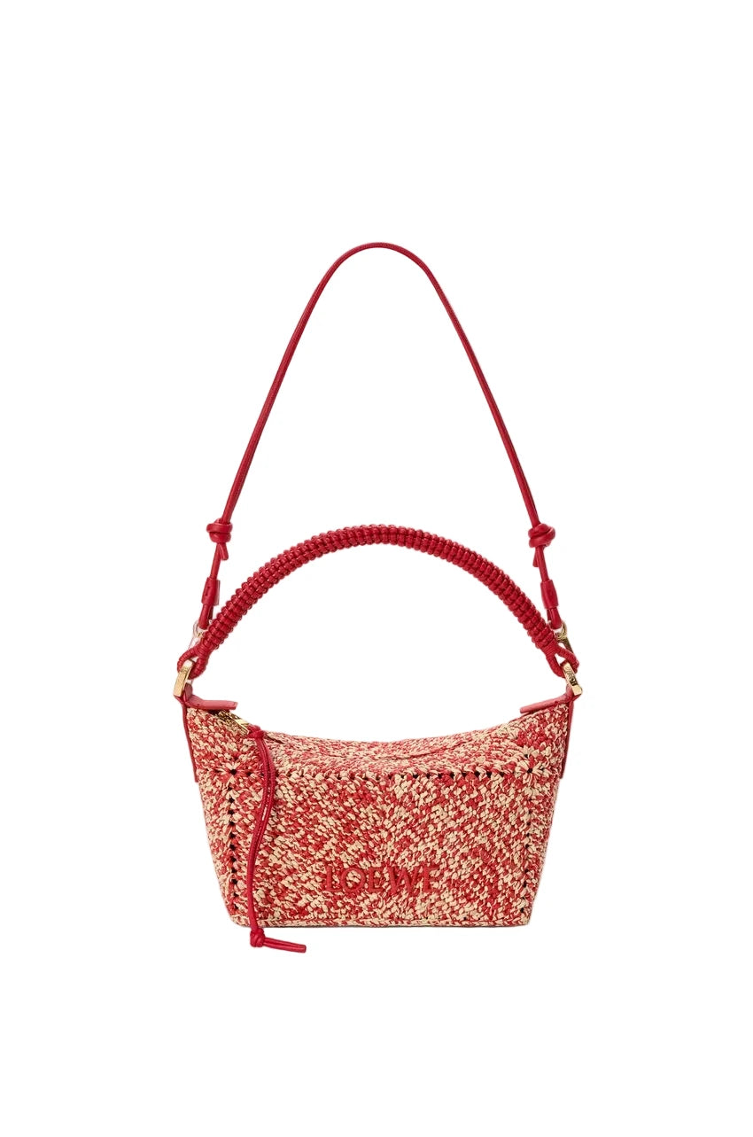 Red woven handbag with a strap on a white background