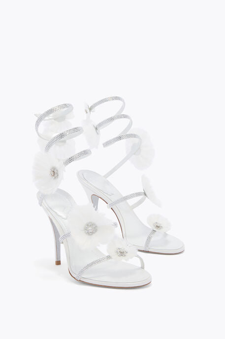 White high-heeled sandals with clear straps on a white background
