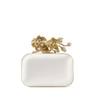 White clutch with gold floral design on a white background