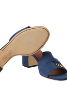 Blue open-toe sandal with a gold buckle on a white background