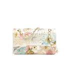 An embroidered flap shoulder bag with a cream base, featuring pink, blue, and gold floral motifs, a gold chain strap, and a gold interlocking CC turn-lock clasp.
