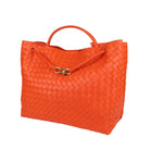 Orange woven handbag with a gold clasp on a light gray background