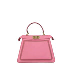 A pink leather handbag with a structured rectangular shape, top handle, and gold-tone hardware, photographed against a plain light gray background.