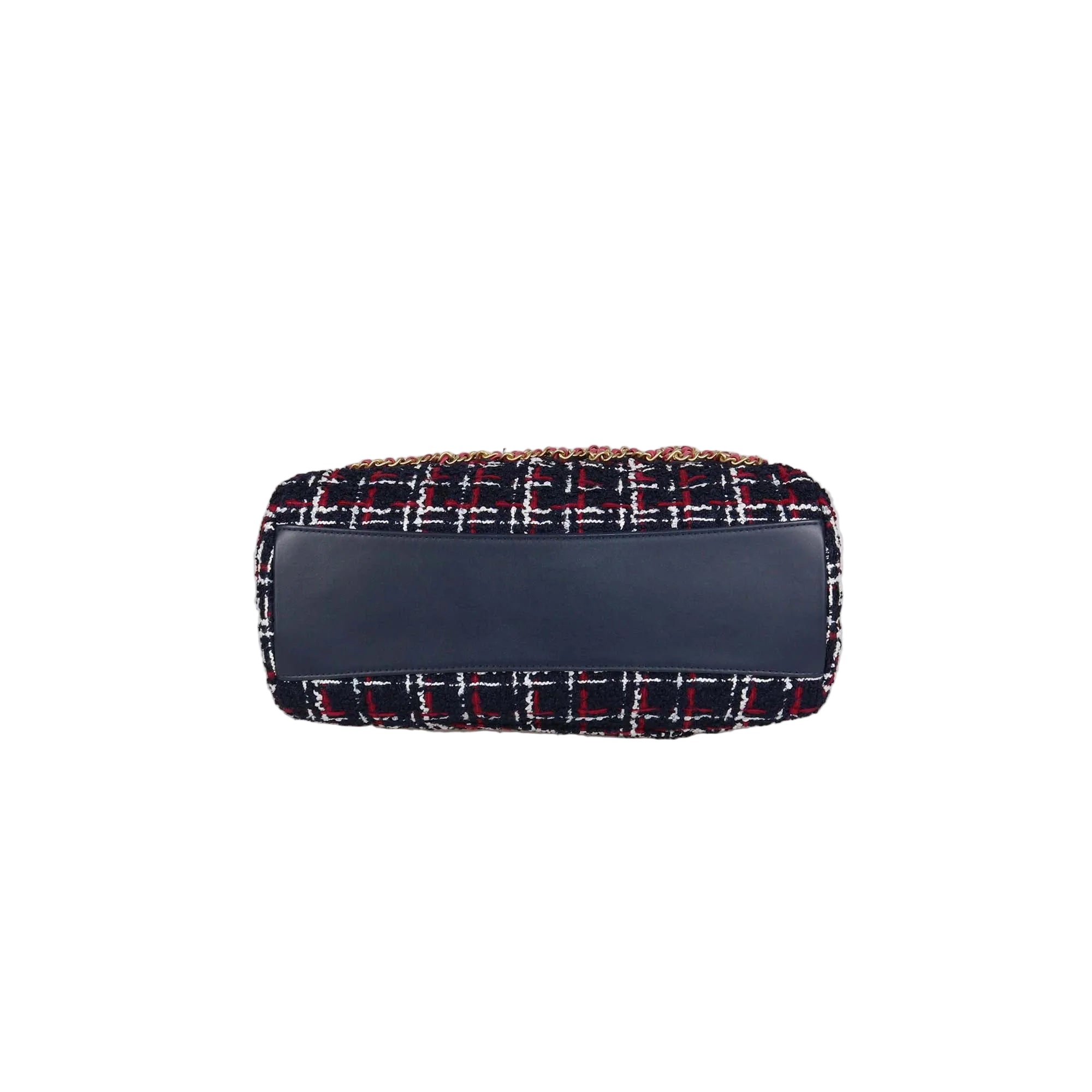 A small rectangular handbag with a navy blue leather front panel and a navy tweed body featuring red, white, and gold woven details, shown against a plain light gray background.