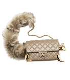 Beige quilted handbag with gold accents and a fur-lined interior on a white background