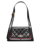 Black quilted handbag with a gold buckle on a white background