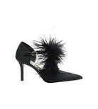 Black high-heeled shoe with feather detail on a white background