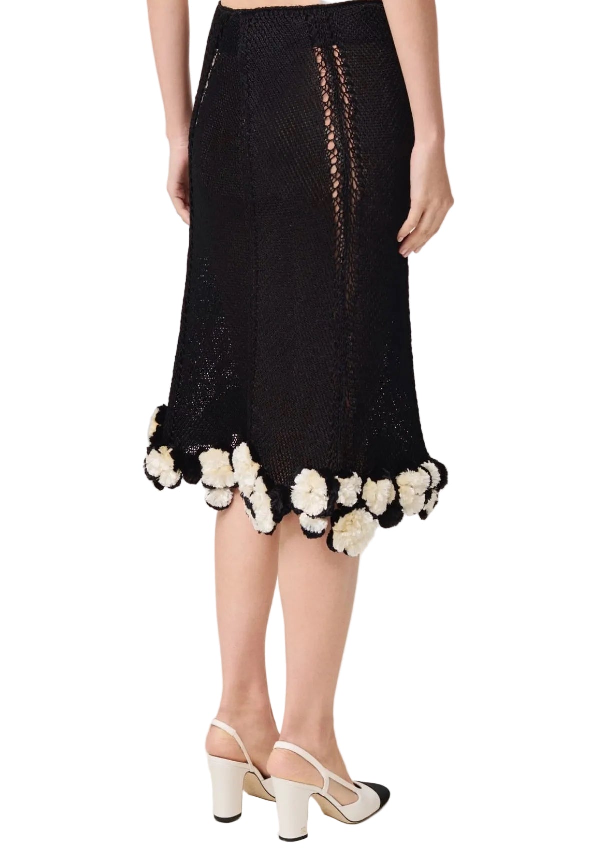 Black skirt with floral details worn by a person on a white background