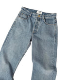 Pair of light blue jeans on a beige carpet