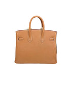 Brown leather handbag on a white surface with a black background