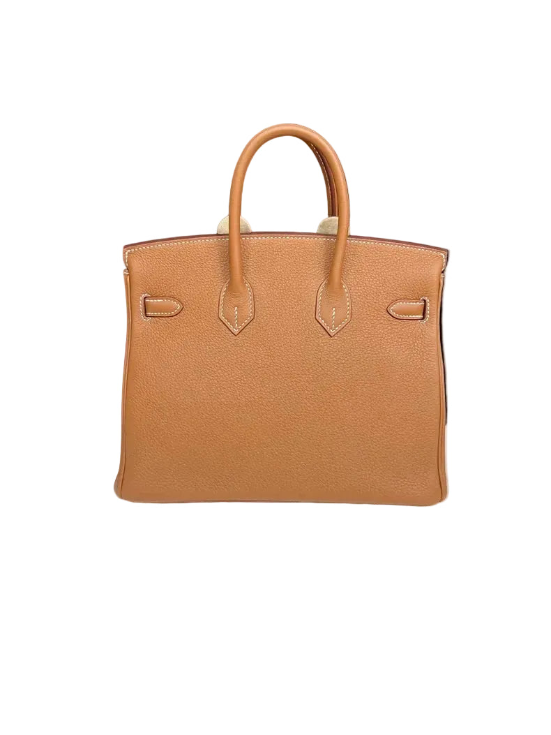 Brown leather handbag on a white surface with a black background