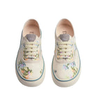 Pair of floral sneakers with Dior branding on a light gray background