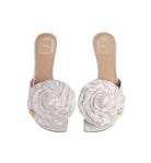 White sandals with floral designs on a light gray background