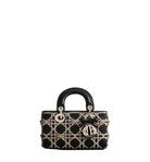 Black handbag with gold accents on a light gray background