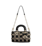 Black handbag with gold accents on a light gray background