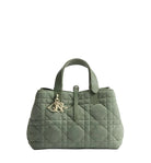 Green quilted handbag with a brand logo on a light gray background