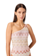 Woman wearing a one-shoulder patterned dress on a white background
