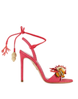 Pink high-heeled sandal with tassel and embellishments on a white background