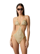 Woman wearing a gold and beige patterned swimsuit on a white background