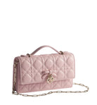 Pink quilted handbag with gold chain on a light gray background