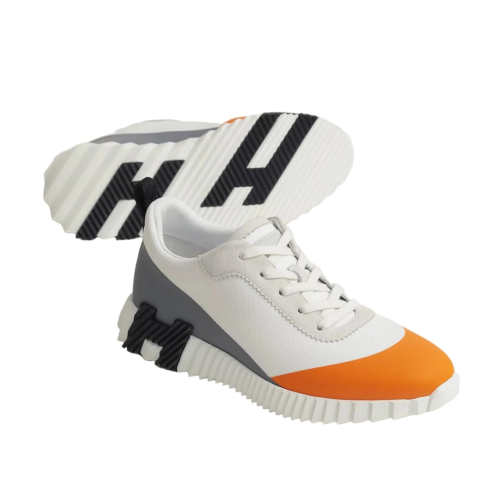White sneaker with orange and gray accents on a light background