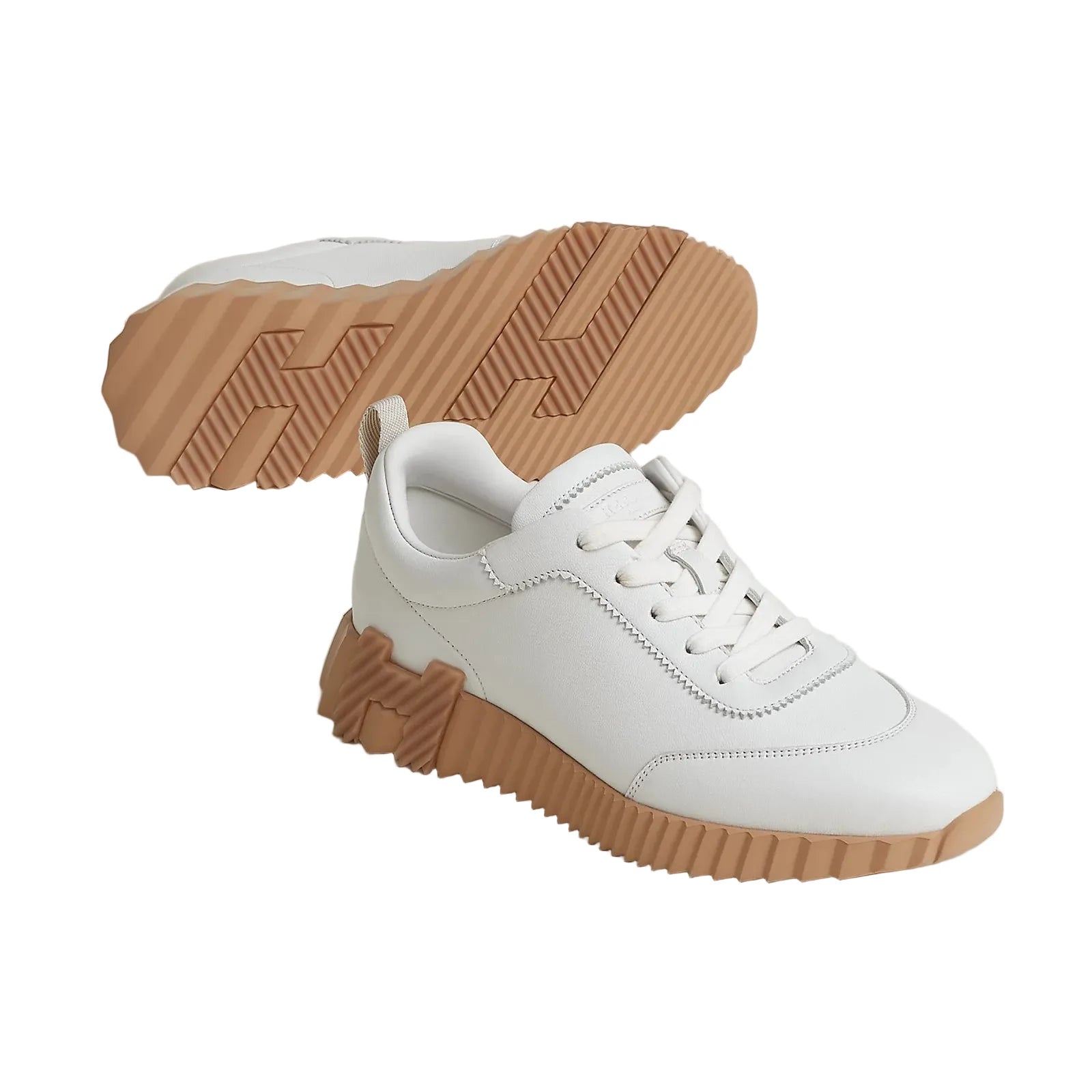 White sneakers with brown soles on a light gray background