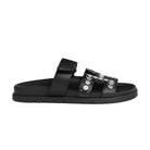 Black sandal with metallic accents on a light gray background