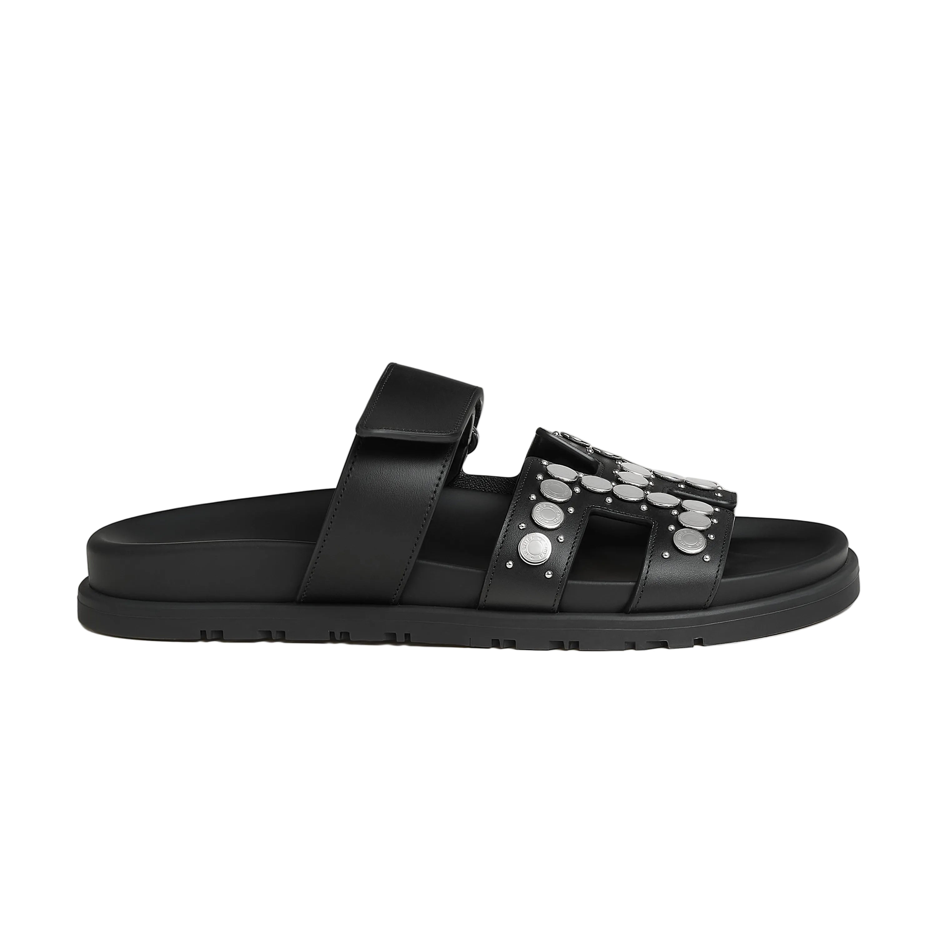 Black sandal with metallic accents on a light gray background