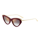 Cat-eye sunglasses with gold frame and maroon gradient lenses on a light gray background
