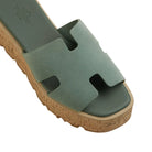 Green sandal with cork sole on a light gray background