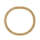 A gold-toned spiked chain-link necklace arranged in a circle on a clean, off-white background.