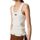 White tank top with lace trim worn by a person on a beige background